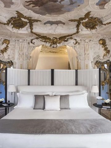 Prächtige Suite mit opulentem Deckenfresko und luxuriösem Bett.