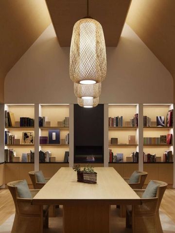 Elegante Bibliothek mit Holzdecke und modernen Lesesesseln