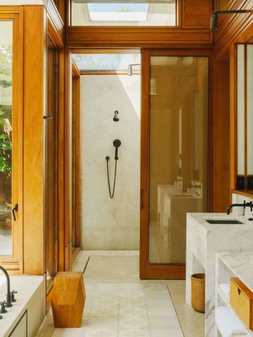 Helles Badezimmer mit Holzelementen und Regendusche