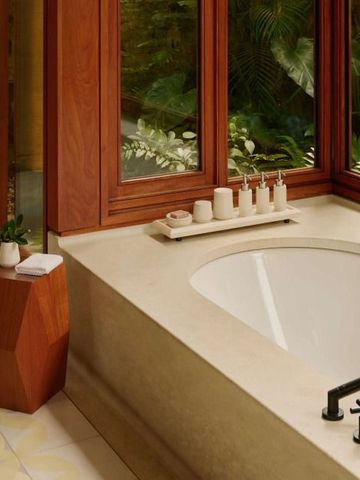 Badezimmer mit großer Badewanne und Blick auf den Garten