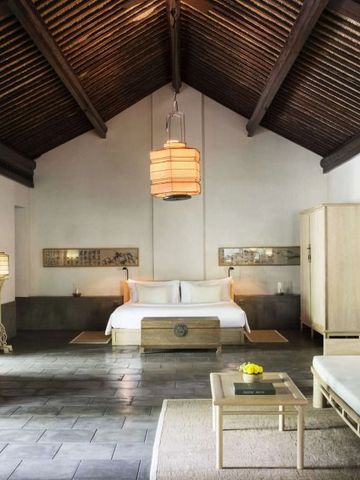 Luxuriöses Schlafzimmer mit Holzdecken und elegantem Mobiliar im Amanfayun Hotel