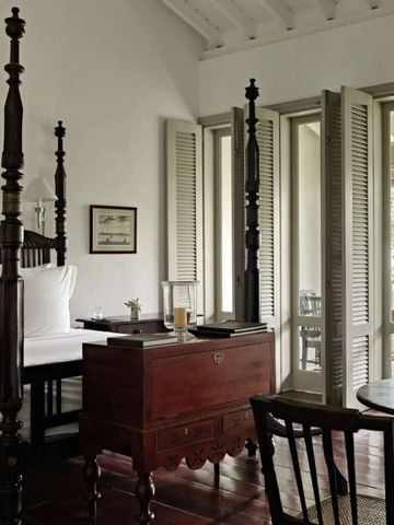 Geräumiges Zimmer im Amangalla Hotel mit Himmelbett und eleganter Einrichtung