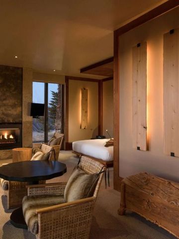 Luxuriöse Suite mit Kamin, Sitzbereich und Bergblick.