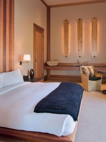 Helles Zimmer mit großem Bett und stilvollen Holzdetails.