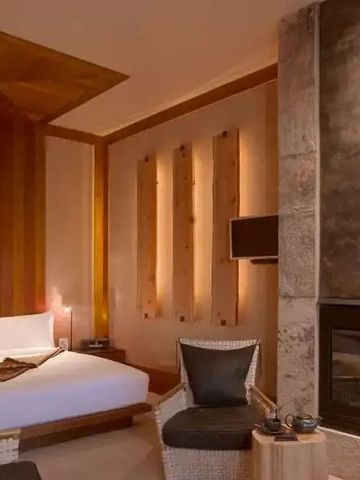 Elegantes Hotelzimmer mit modernem Kamin und stilvollen Holzelementen