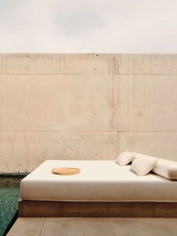 Sonnenterrasse mit Liege am Rand eines stillen Pools