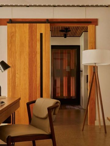 Modernes Hotelzimmer mit Holzschiebetür und elegantem Schreibtisch.