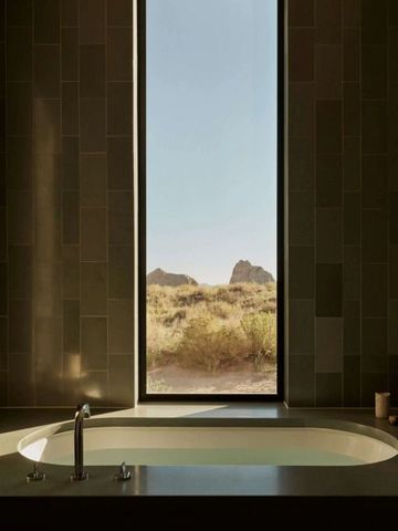 Luxuriöses Badezimmer mit Badewanne und Panoramablick auf Wüstenlandschaft.