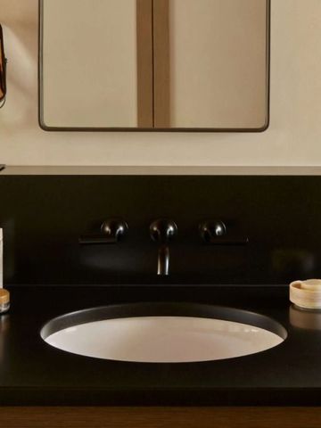 Schlichtes Badezimmer mit stylischem Waschbecken und modernen Accessoires.