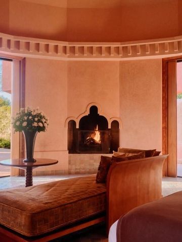 Luxuriöse Suite mit Kamin und Panoramablick in warmen Erdtönen.