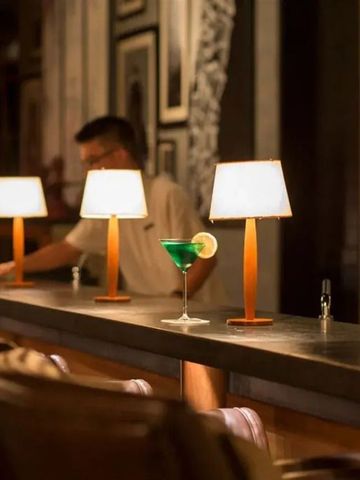 Stilvolle Bar mit sanfter Beleuchtung und einem grünen Cocktail