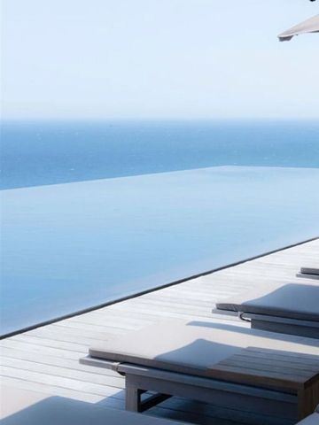 Infinity-Pool mit ruhigem Meerblick unter klarem Himmel