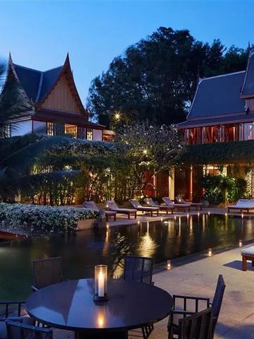 Luxuriöser Hotelpool bei Dämmerung mit eleganten Liegen und stilvollen Gebäuden.