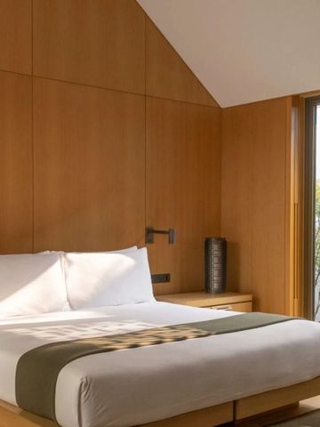 Modernes Schlafzimmer mit großem Fenster und natürlichem Licht.