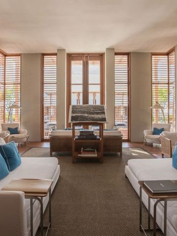 Heller Aufenthaltsraum mit weißen Sofas und blauen Kissen