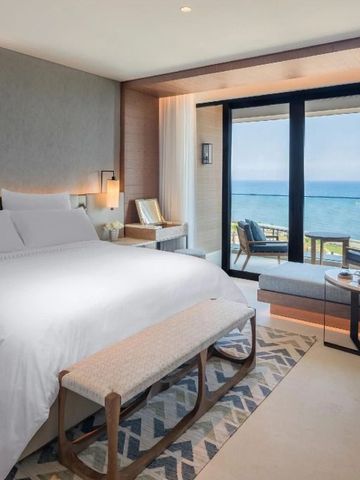 Helles Zimmer mit Meerblick durch große Fenster und stilvoller Einrichtung