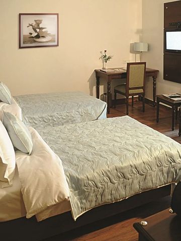 Doppelzimmer mit zwei Betten und stilvollem Arbeitsbereich