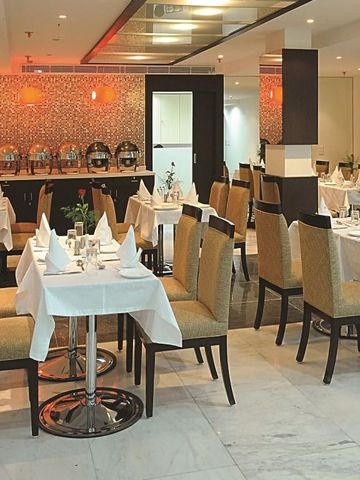 Elegantes Hotelrestaurant mit gedeckten Tischen und warmer Beleuchtung