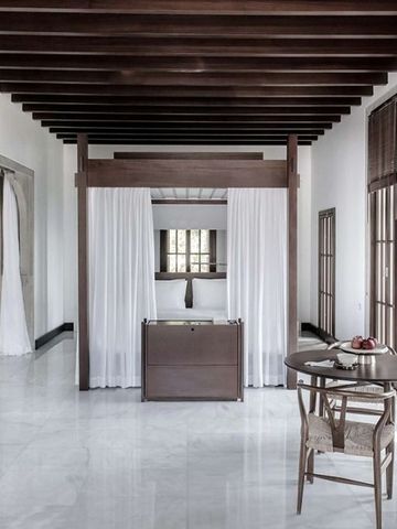 Helles Zimmer mit Baldachinbett und Holzelementen im Amanruya Hotel