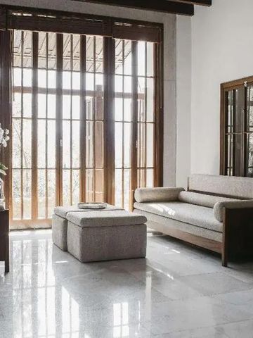 Moderne Sitzecke mit großen Fenstern und Holztüren