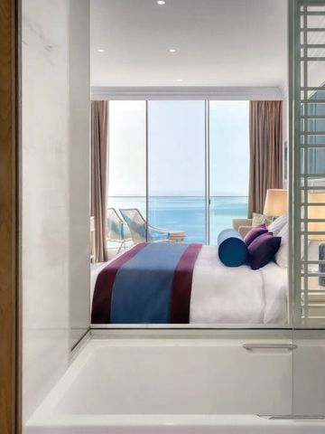 Badezimmer mit Blick auf das stilvolle Schlafzimmer und das Meer im Hintergrund