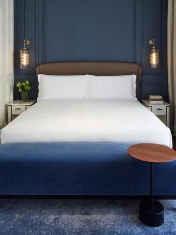 Kingsize-Bett mit blauem Hintergrund im luxuriösen Hotelzimmer