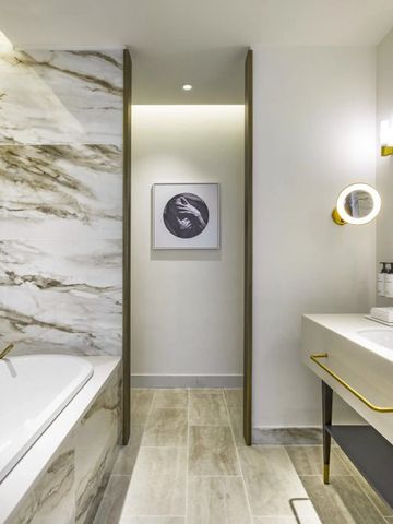 Luxuriöses Badezimmer mit Marmordetails und eleganter Beleuchtung