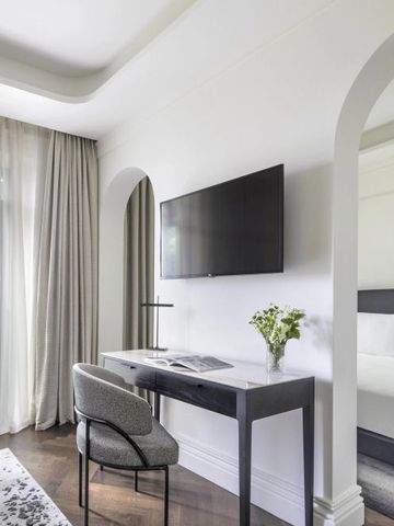 Geräumiges Zimmer mit Schreibtisch und großem Fenster, elegant dekoriert