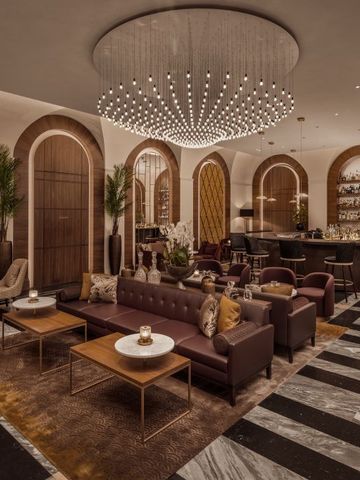 Elegante Lounge mit stilvoller Beleuchtung und Bar im Hintergrund