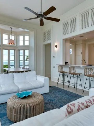 Helle Lounge mit weißen Sofas und Blick auf das Meer durch große Fenster