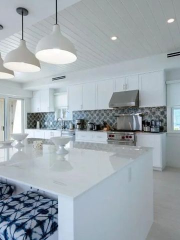 Offene Küche mit großer Insel und stilvollen Hängelampen.