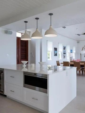 Elegante Küche mit großem Inselbereich und Essbereich im Hintergrund