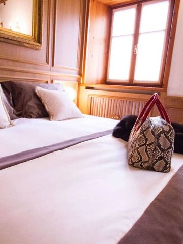 Gemütliches Hotelzimmer mit Doppelbett und dekorativer Tasche auf der Bettdecke