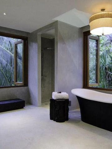 Badezimmer mit freistehender Badewanne und Ausblick ins Grüne