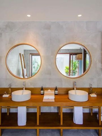 Doppelwaschbecken mit runden Spiegeln im optimal beleuchteten Badezimmer