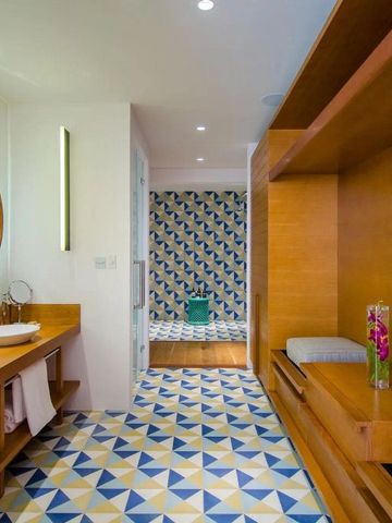 Badezimmer mit gemusterten Fliesen und Holzverkleidung