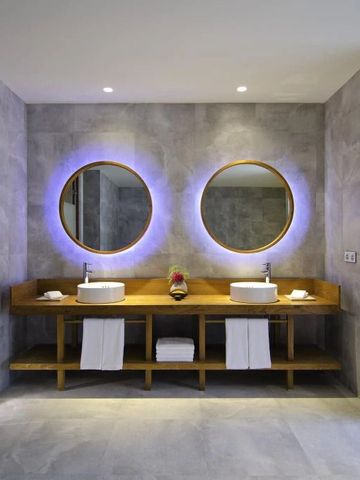 Elegantes Badezimmer mit Doppelwaschbecken und beleuchteten Spiegeln