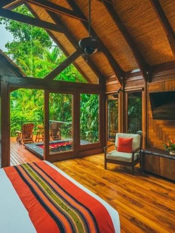 Luxuriöses Zimmer mit Holzdekor und Fensterausblick auf Wald