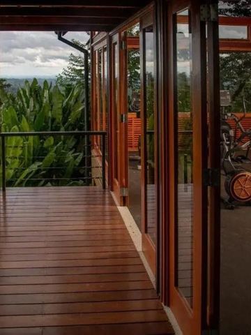 Holzterrasse mit Fitnessgerät und Baumlandschaft