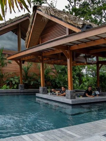 Luxuriöser Hotelpool mit überdachter Sitzgelegenheit und tropischen Pflanzen