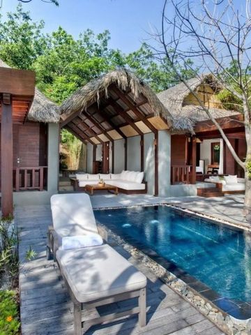 Luxuriöse Poolvilla mit bequemen Liegen und viel Grün