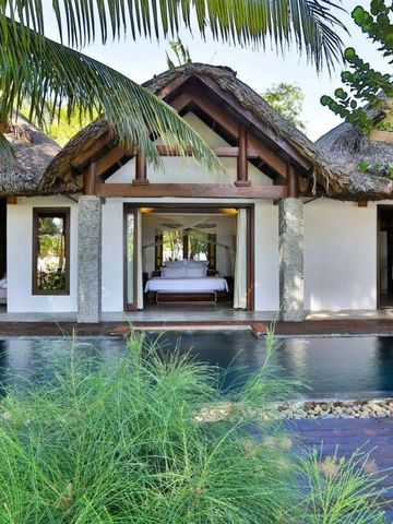 Villa mit offenem Schlafbereich und Pool von Palmen umrahmt