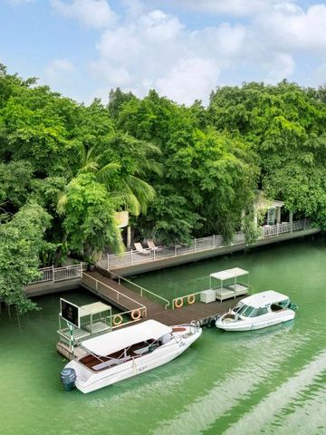 Anlegestelle mit Booten am grünen Saigon River umgeben von tropischer Vegetation.