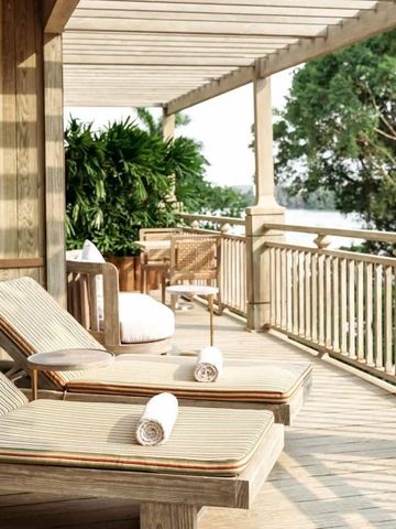 Holzterrasse mit zwei Sonnenliegen und atemberaubender Aussicht auf den Fluss und die Natur
