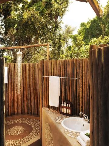 Freiluft-Dusche mit hölzernem Sichtschutz in natürlicher Umgebung