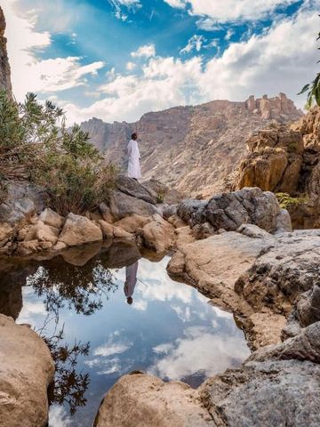 Berglandschaft mit kleinem Wasserbecken und Person im Hintergrund
