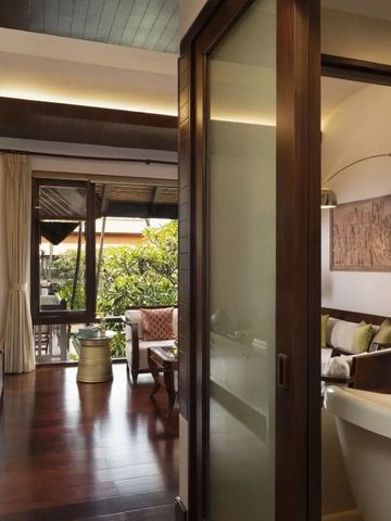 Stilvolles Wohnzimmer mit freistehender Badewanne und Holzboden