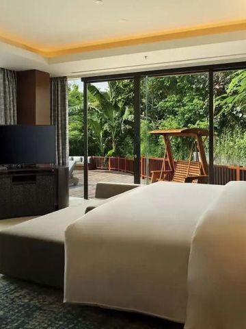 Luxuriöse Hotelsuite mit Blick auf privaten Pool und üppigen Garten.