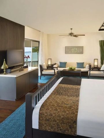 Modernes Zimmer mit offenem Wohnbereich und Blick auf den tropischen Außenbereich