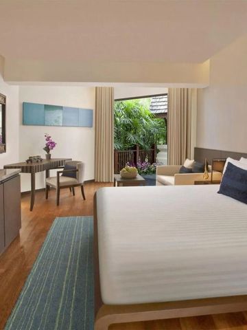 Elegantes Zimmer mit Blick auf den Balkon und tropischer Dekoration.